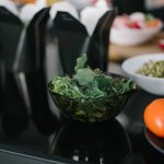 Close-up of fresh vegetables and takeout containers in a kitchen setting.